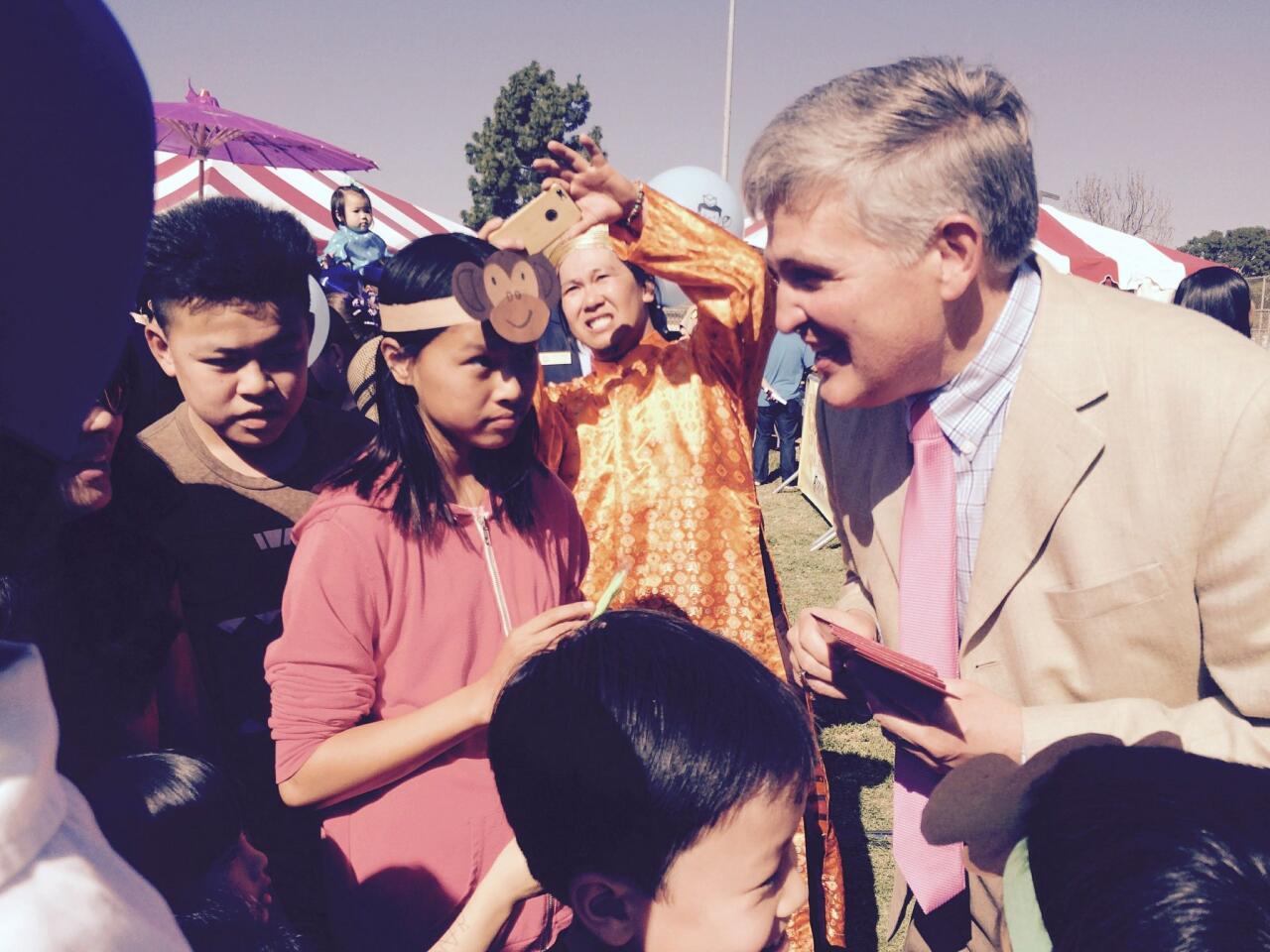 County Supervisor Dave Roberts hands out traditional red Li Xi envelopes to celebrate the Vietnamese Lunar New Year at the San Diego Tet Festival 2016.