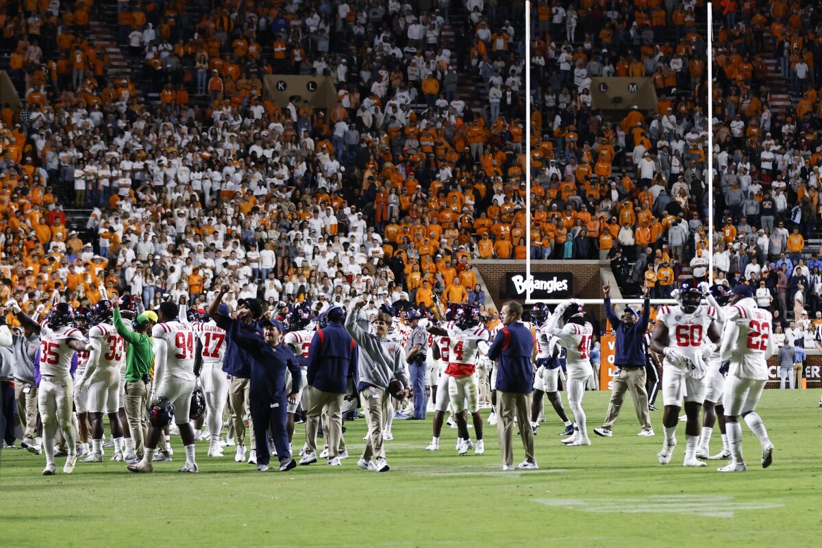 Mississippi players stand on the field after the game was delayed because of fans throwing bottles onto the field during the second half of the team's NCAA college football game against Tennessee, Saturday, Oct. 16, 2021, in Knoxville, Tenn. Mississippi won 31-26. (AP Photo/Wade Payne)