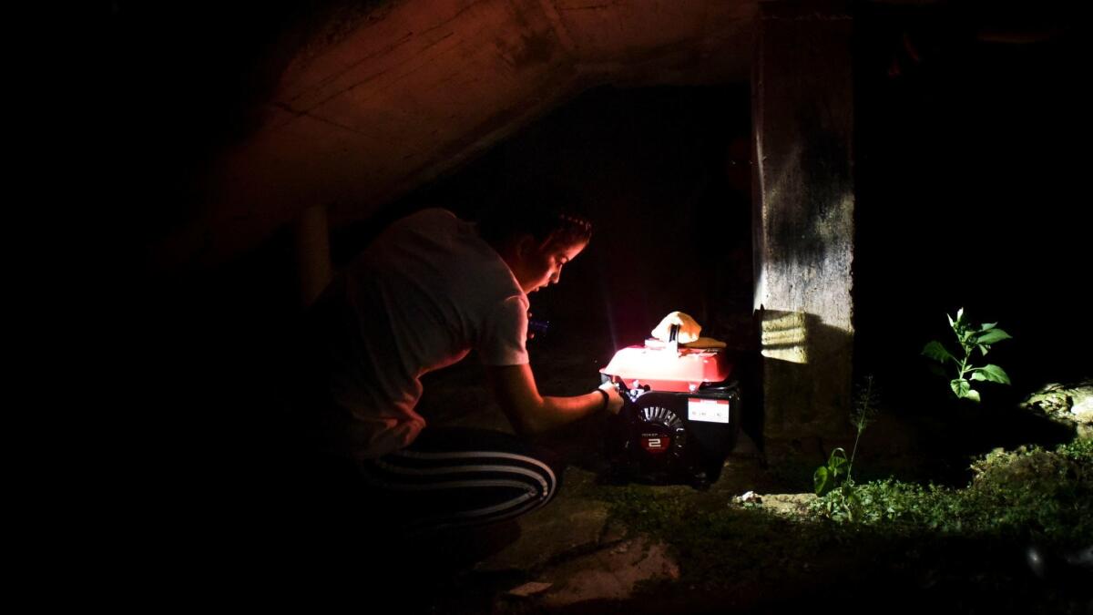 In this Dec. 21 photo, barrio Patron resident Karina Santiago Gonzalez works on a small power plant in Morovis, Puerto Rico. Puerto Rico authorities say nearly half of the power customers in the U.S. territory still lack electricity more than three months after Hurricane Maria.