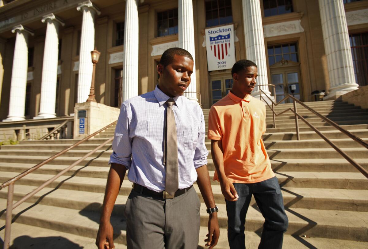 Michael Tubbs, left, a recent Stanford graduate who won a City Council seat in Stockton, walks with a friend on the steps of City Hall last summer. After residents passed a tax measure Tuesday night to bring badly needed revenue for the bankrupt city, he said "We're all breathing a little easier."