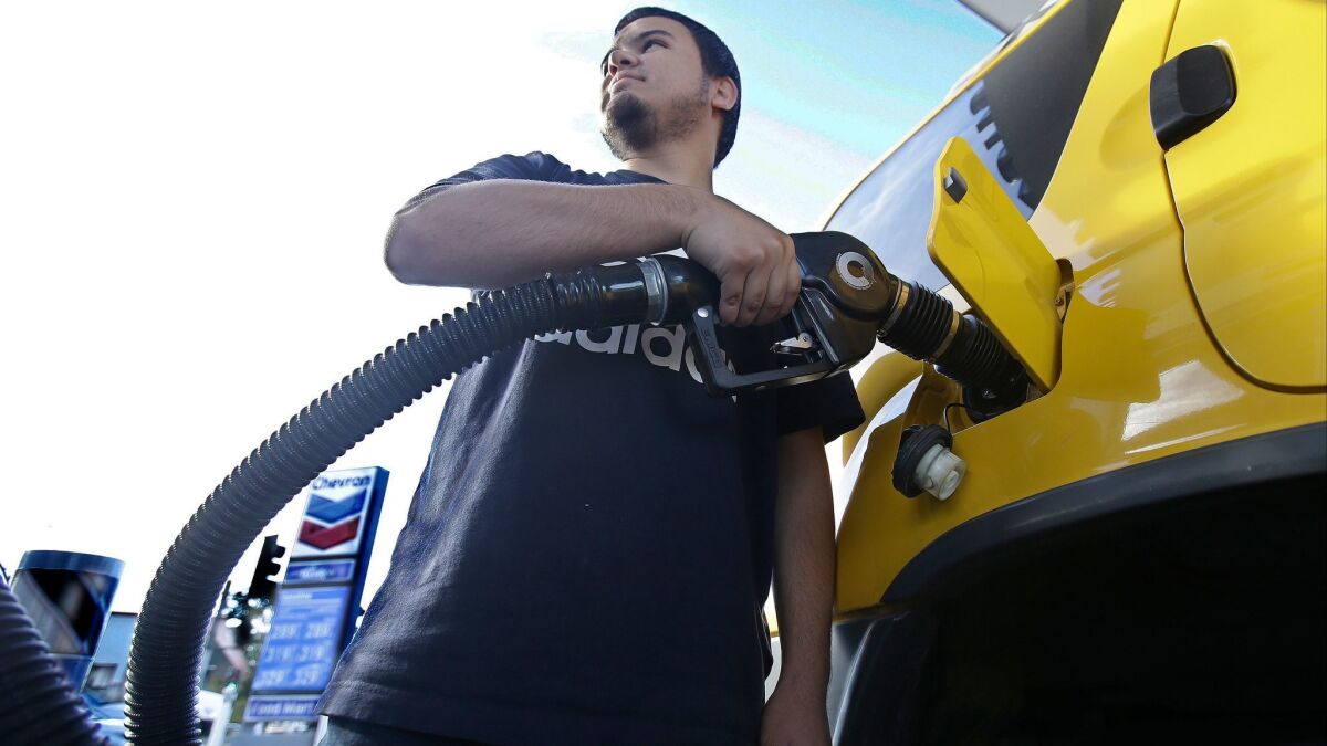 Cristian Rodriguez fuels his vehicle in Sacramento. Gasoline taxes rose by 12 cents per gallon Wednesday to raise money for fixing roads and highways. It is the first of several tax and fee hikes that will take effect after they were approved by the Legislature.