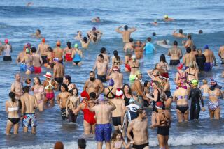 San Diego CA - January 1: People take part in the annual New Year's Day Polar Bear Plunge at La Jolla Shores on Monday, January 1, 2024 in San Diego, CA. Hundreds of people braved the not so cold water for a New Year's Day dunk in the ocean, where temperatures were above 60 degrees. (K.C. Alfred / The San Diego Union-Tribune)