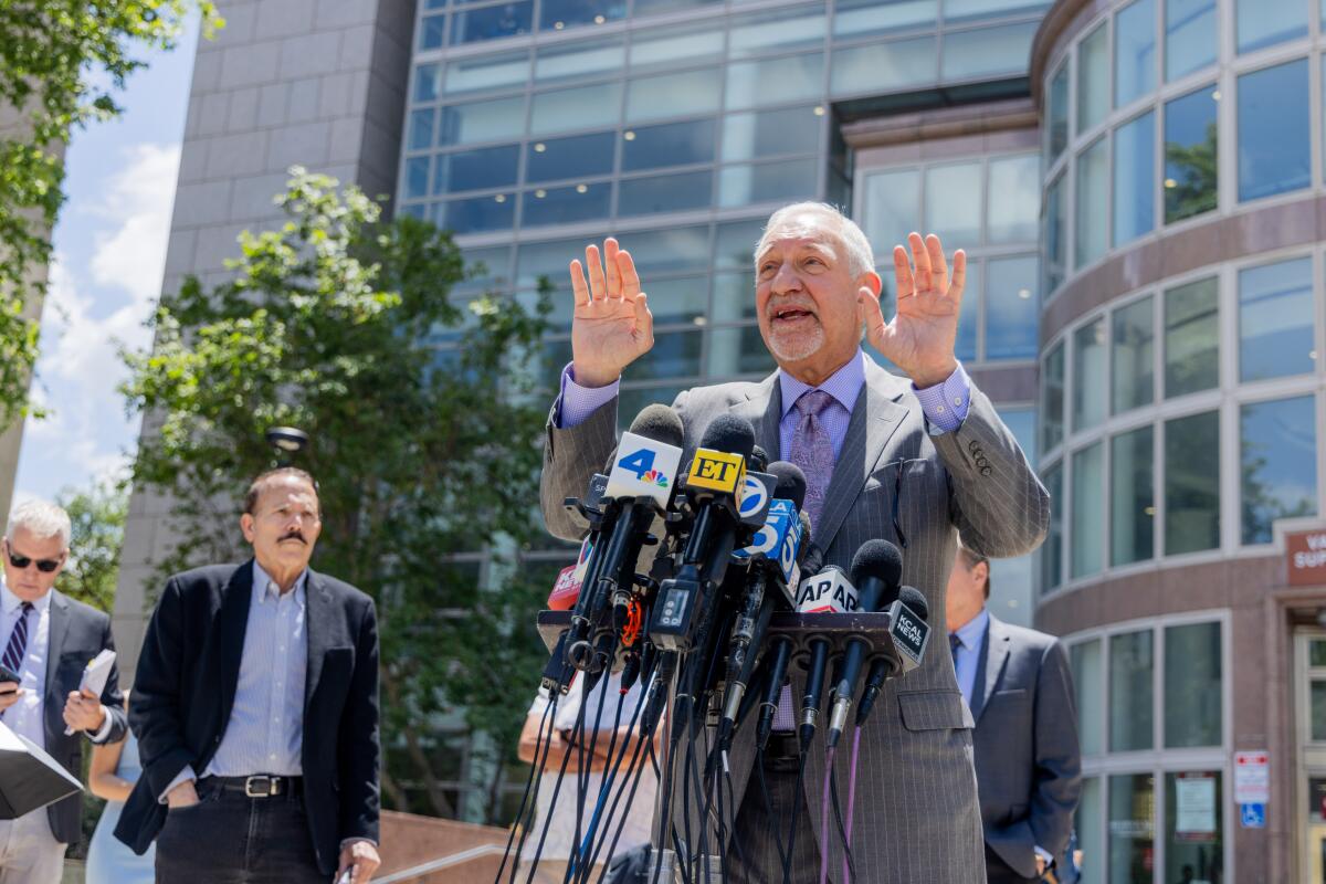 Mark Geragos stands outdoors speaking into microphones.