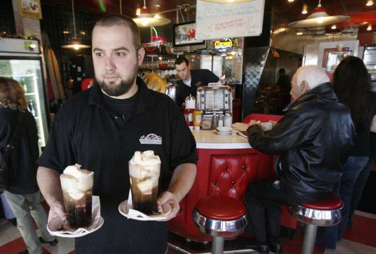 David Gemberling, serving floats, has worked at Rocky Cola Cafe for 10 years. The diner, which has been open nearly 25 years, will close Sunday due to a downturn in the economy and local competition.