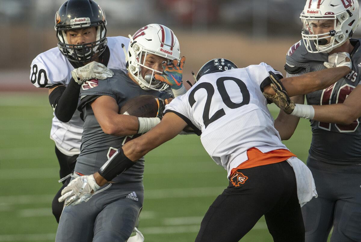 Los Amigos' Adam Aly, left, and Adolfo Chavez, right, wrap up Ocean View's Anthony Ramirez in a nonleague game on Aug. 30.