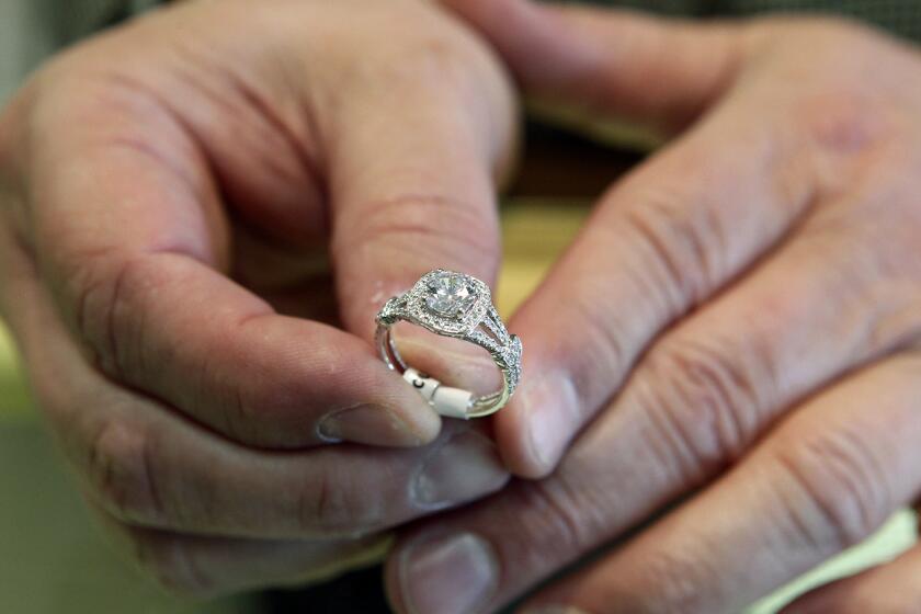 FILE - In this May 14, 2014, file photo, Brad Padgett, owner of Bradley's Jewelers, shows off one of his favorite engagement rings in Jacksonville, N.C. There’s a common misconception that prenuptial agreements are only for protecting the assets of an ultra-wealthy person from their spouse, but they can do much more. (Maria Sestito/The Jacksonville Daily News via AP, File)