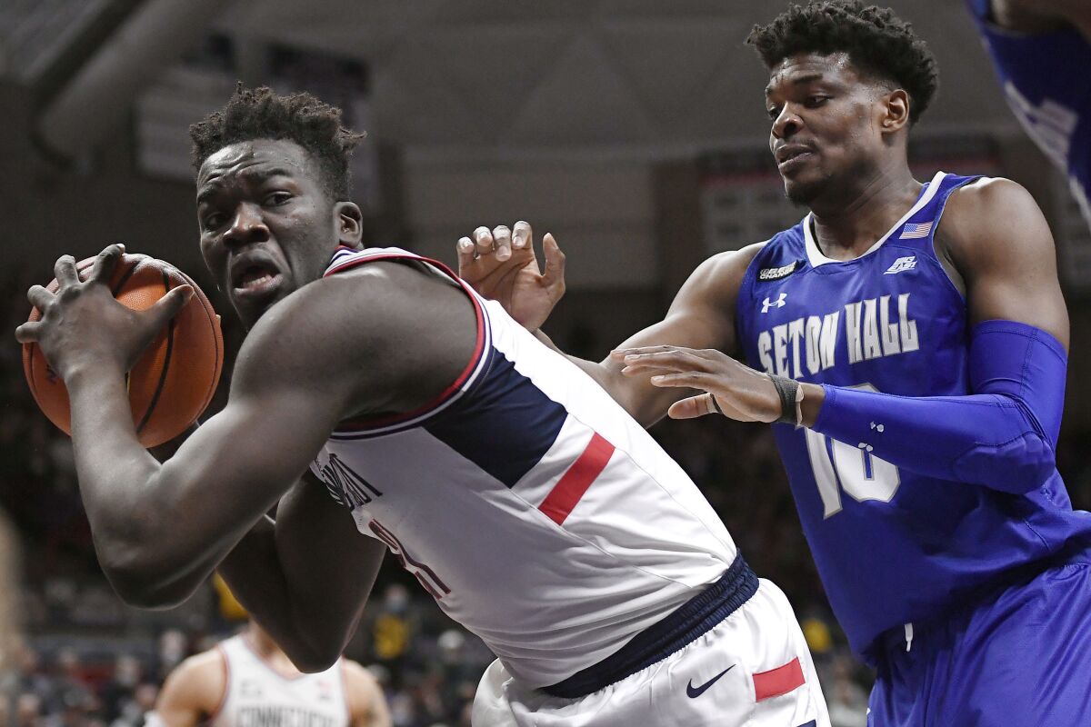 Connecticut's Adama Sanogo is guarded by Seton Hall's Alexis Yetna (10) during the first half of an NCAA college basketball game Wednesday, Feb. 16, 2022, in Storrs, Conn. (AP Photo/Jessica Hill)
