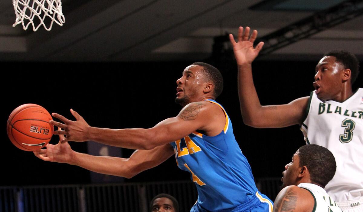 UCLA guard Norman Powell tries to get a grip on the basketball as he battles Alabama Birmingham's Chris Cokley and Lewis Sullivan. The Bruins won the game against the Blazers, 88-76, in November.