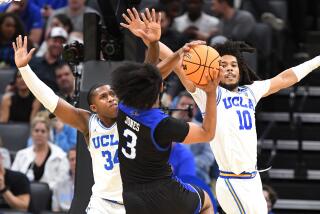 UCLA's David Singleton, left, and Tyger Campbell defend UNC Asheville's Tajion Jones in the NCAA tournament March 16, 2023.