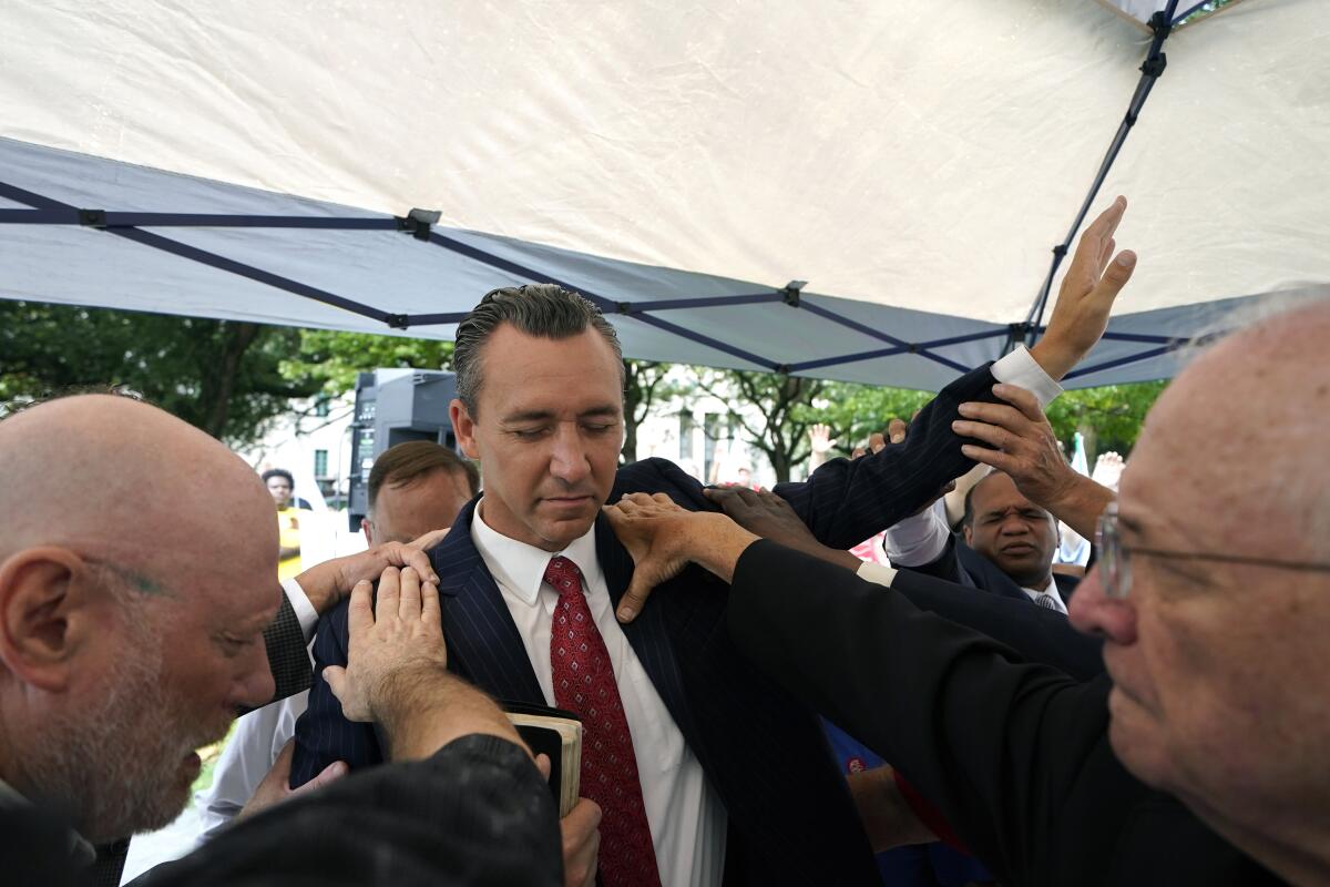 FILE - Tony Spell, pastor of the Life Tabernacle Church of Central City, La., prays with supporters outside the Fifth Circuit Court of Appeals in New Orleans on June 7, 2021. An outspoken Christian conservative attorney from Alabama has asked a federal appeals court to revive the Louisiana pastor’s damage claims against state officials over long-expired COVID-19 restrictions. A federal judge had earlier this year dismissed minister Spell’s lawsuit against Gov. John Bel Edwards and others over enforcement of the ban. Spell drew national attendance for his flouting of the restrictions early in the pandemic at his church in Central, near Baton Rouge. (AP Photo/Gerald Herbert, File)