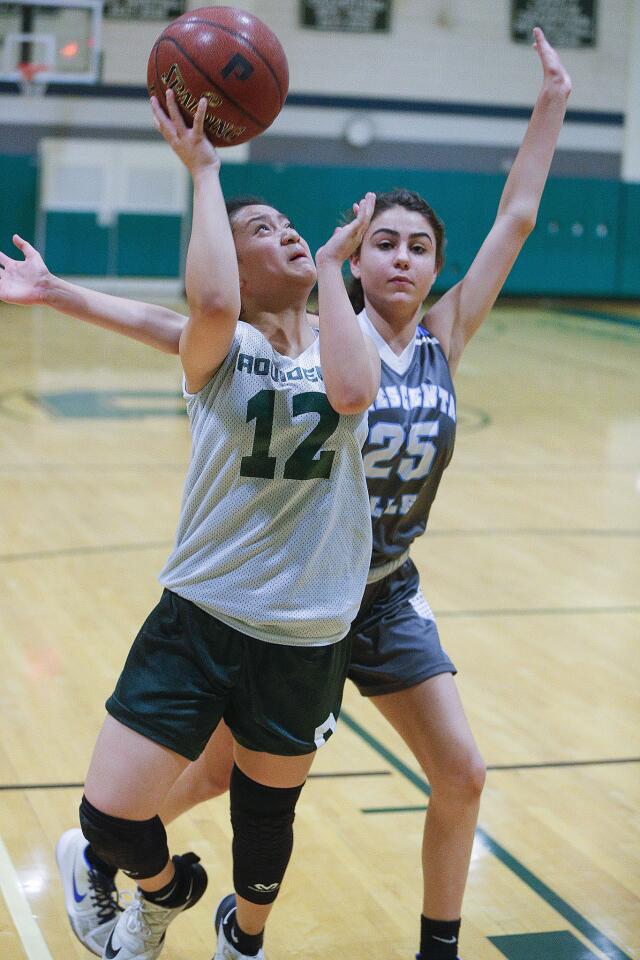Providence's Sydney Sayoc shoots with Crescenta Valley's Katrina Minassian trailing in defense in a summer league girls' basketball game at Providence High School in Burbank on Tuesday, July 9, 2019.