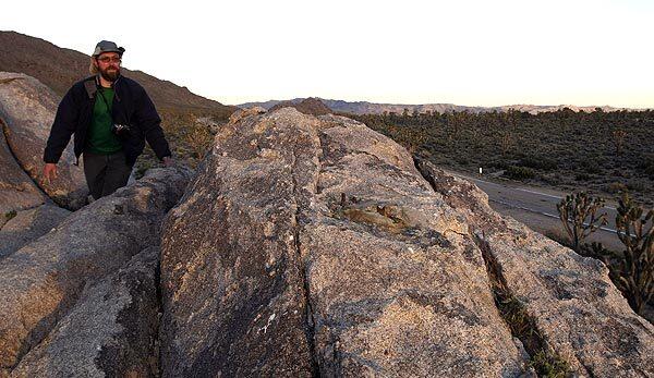 Ken Layne of Yucca Valley climbs to the spot in the Mojave National Preserve where a cross honoring troops who died in World War I vanished. See full story