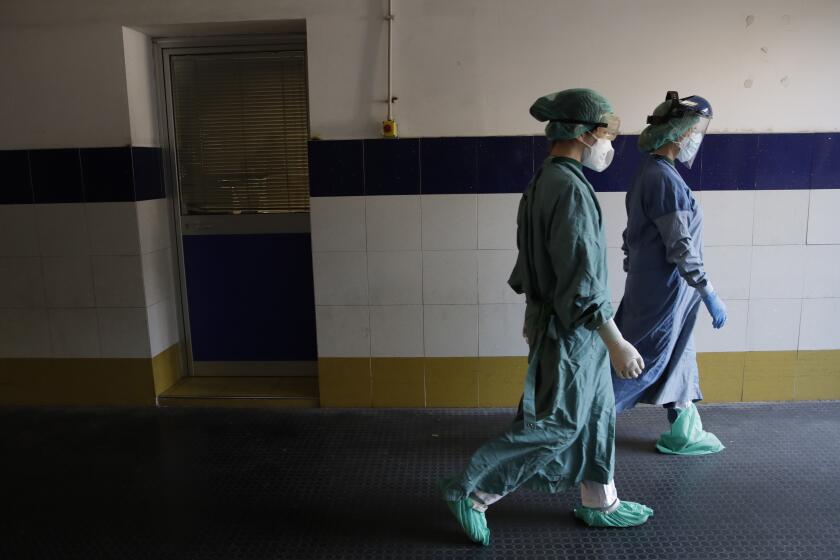 In this photo taken on Sunday, April 12, 2020, medical staffers walk in hall leading to the COVID-19 emergency ward of the Santo Spirito hospital, in Rome. After two months of nightly briefings with only male COVID-19 experts, female scientists in Italy have demanded the government listen to their voices, too. Female lawmakers and a "give us voice” grassroots movement that has sprouted are lending support. (AP Photo/Alessandra Tarantino)