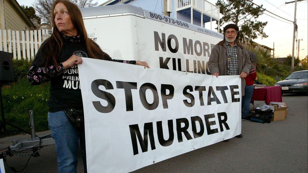Melanie Bostic of Lancaster and Michael Wharton of San Leandro, Calif., protest outside the state prison in San Quentin on Feb. 9, 2004.