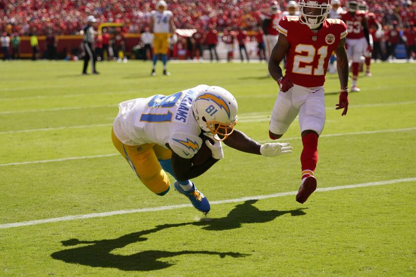 Los Angeles Chargers' Mike Williams (81) makes a touchdown reception against Kansas City Chiefs' Mike Hughes (21) during the second half of an NFL football game, Sunday, Sept. 26, 2021, in Kansas City, Mo. (AP Photo/Charlie Riedel)