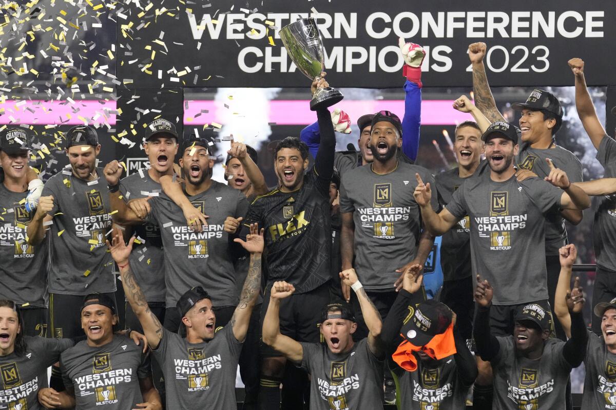 LAFC forward Carlos Vela holds the MLS Western Conference trophy after LAFC's 2-0 victory.