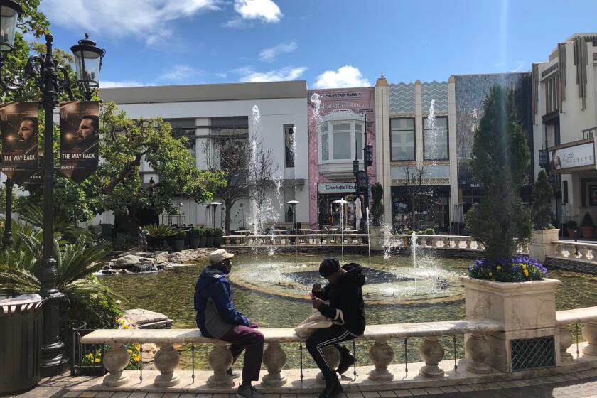Most of The Grove shopping center's stores and restaurants are closed, but on Thursday afternoon owner Rick Caruso still had the lights, fountain and music going.