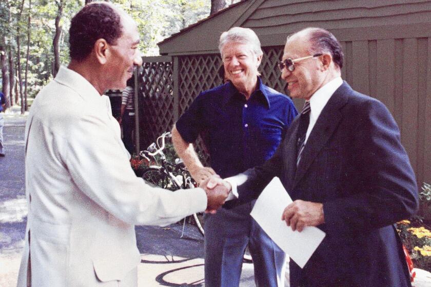 Egyptian President Anwar Sadat, left, shakes hands with Israeli Premier Menachem Begin after meetings at Camp David with President Jimmy Carter in 1978.