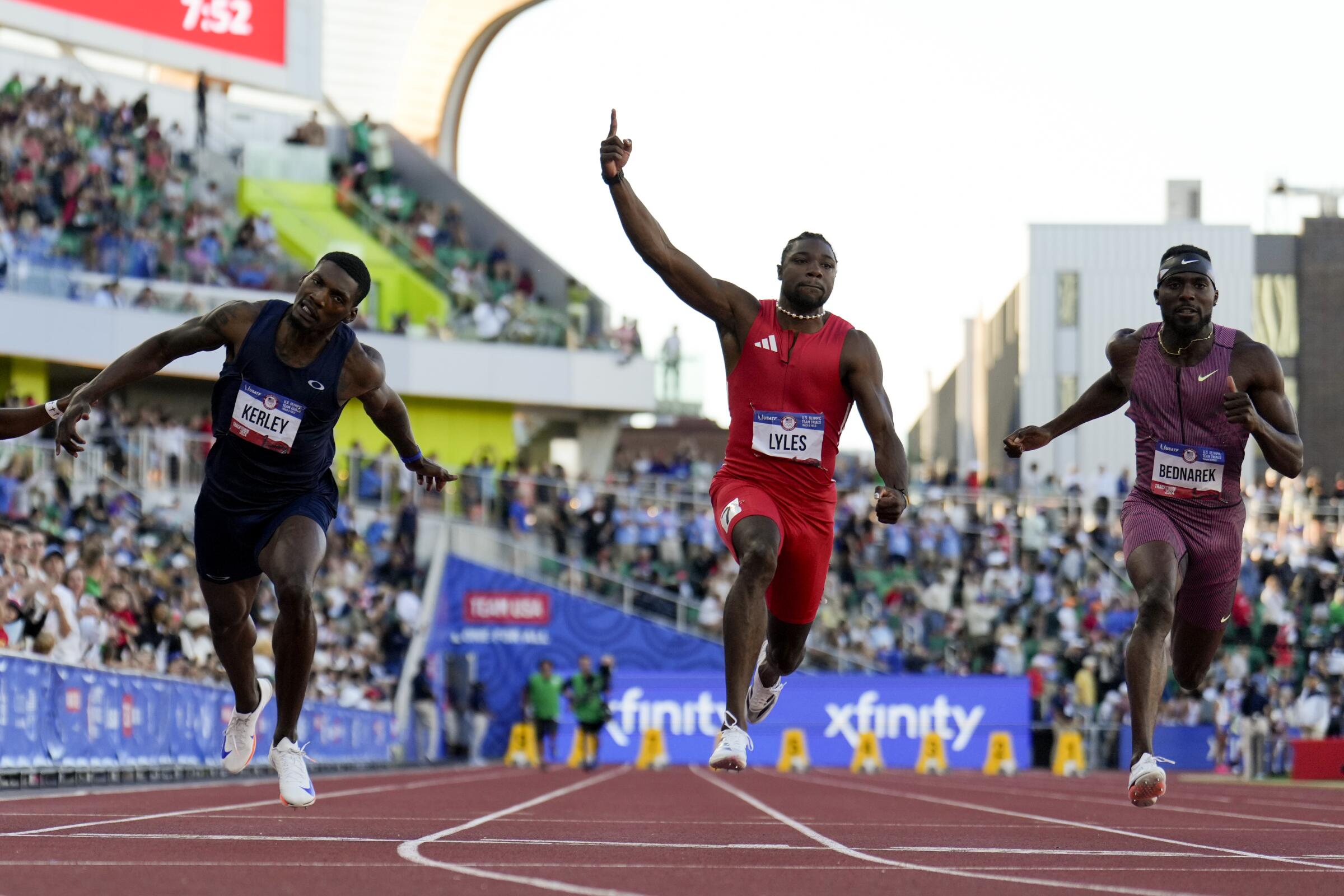 Noah Lyles, center, celebrates after winning the men's 100-meter final at the U.S. Olympic track and field trials on Sunday.