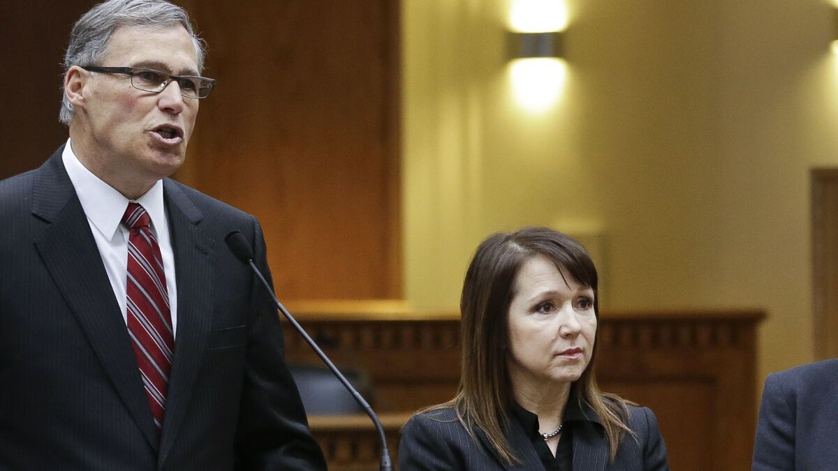 CalPERS CEO Marcie Frost (right), seen in 2013 when she was a public pension official in the administration of Washington Gov. Jay Inslee (left).