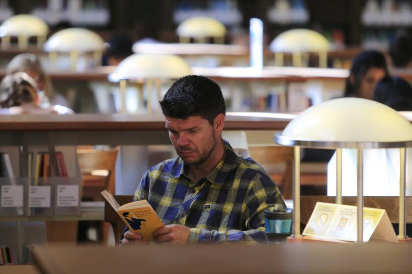 Steven Czifra reads in a UC Berkeley library.