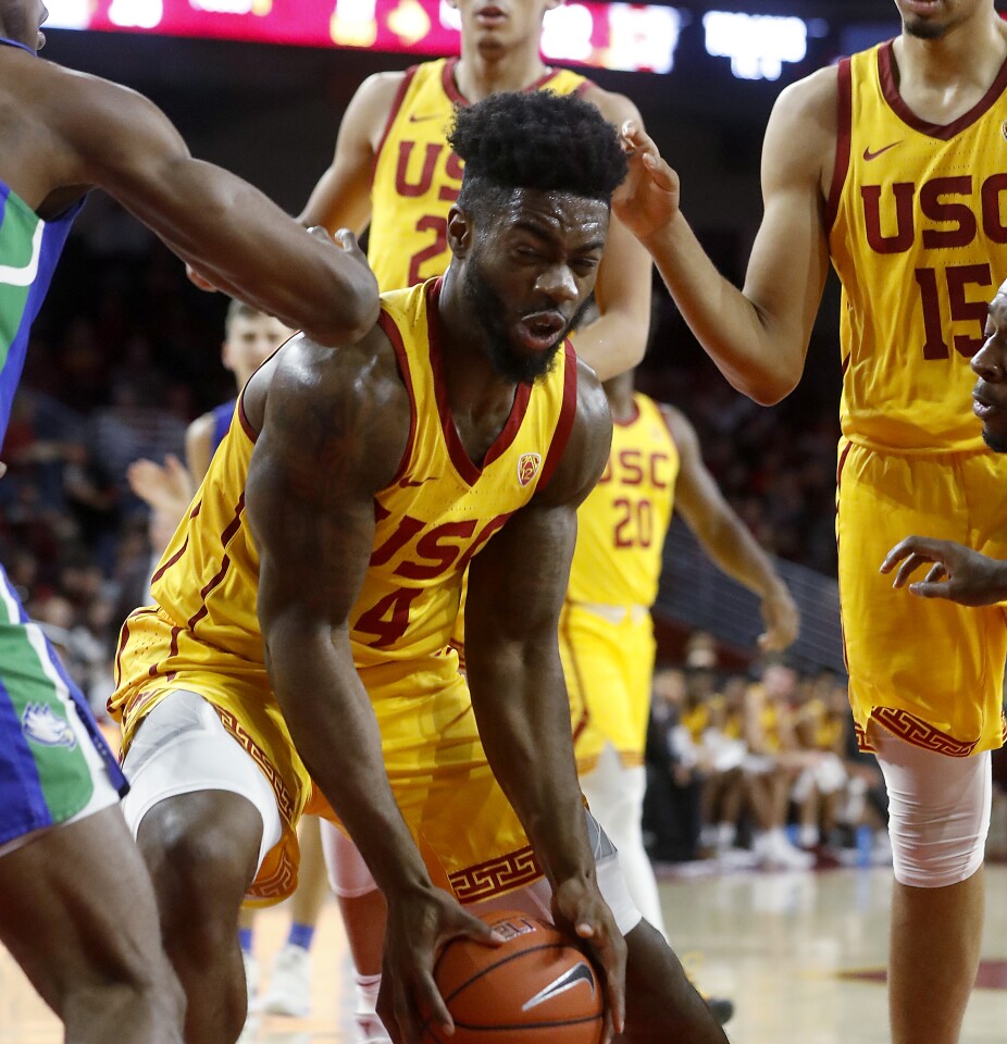 LOS ANGELES, CALIF. - DEC. 29, 2019. USC guard Daniel Utomi works to the basket against a pair of FGCU defenders in the first half Sunday night, Dec. 29, 2019, at Galen Center in Los Angeles. (Luis Sinco/Los Angeles Times)