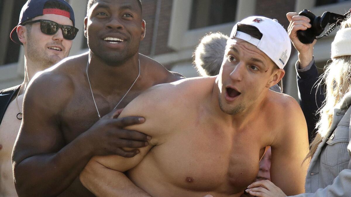 Rob Gronkowski, right, and fellow New England tight end Dwayne Allen interact with fans during a parade through downtown Boston on Feb. 5.