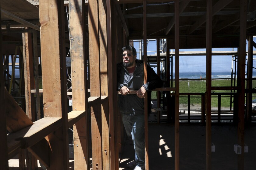 A man stands in a low-income housing complex being rehabbed in San Francisco.
