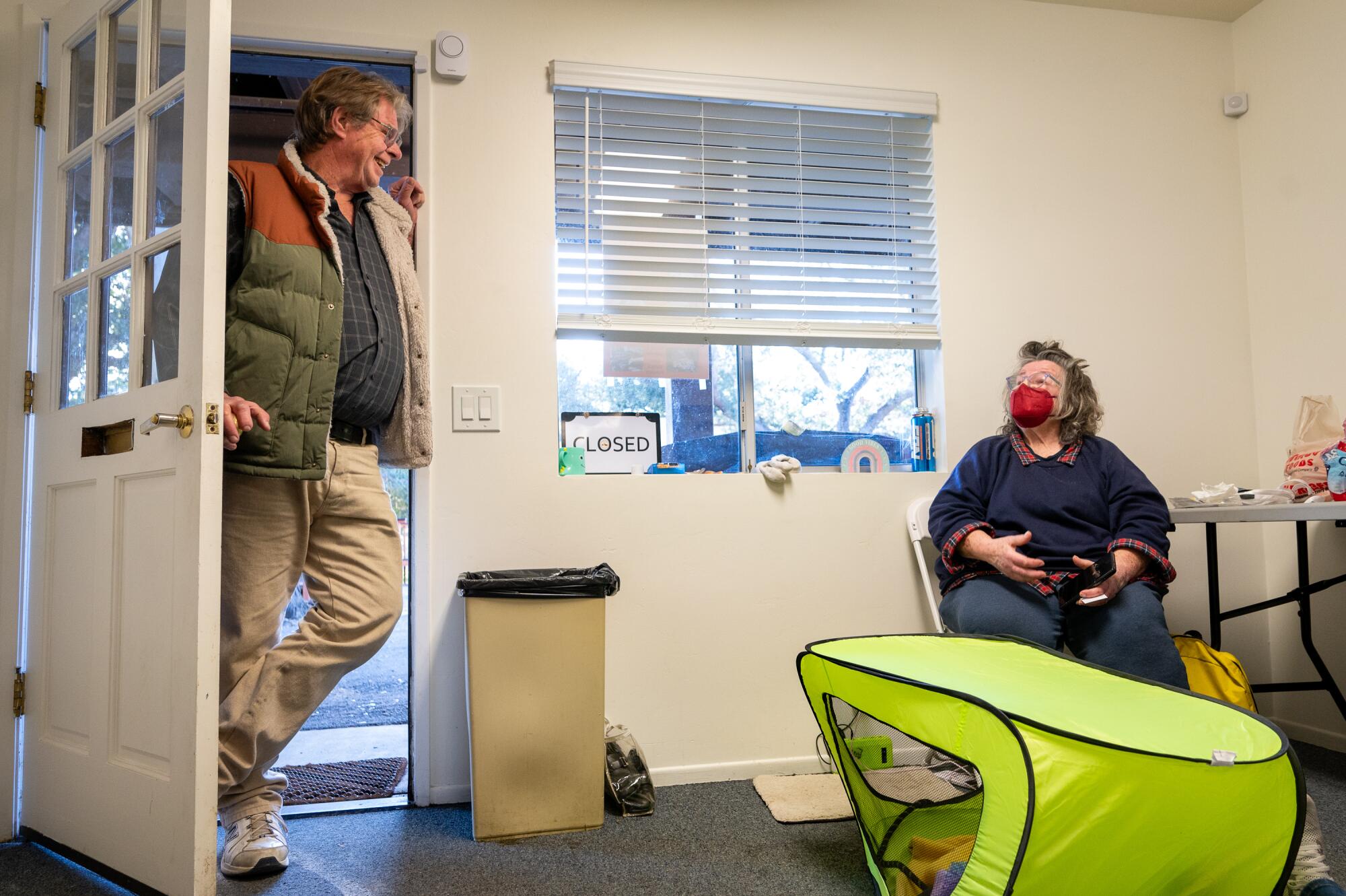 A man and woman converse in a community room at Ojai's homeless encampment.