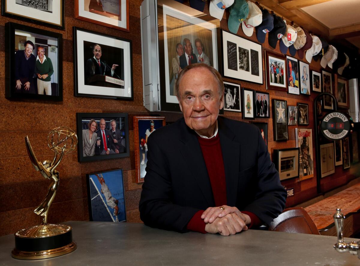 San Diego Padres broadcaster Dick Enberg at his home in La Jolla, amid framed photographs, including those of him with former broadcast partner Al McGuire.