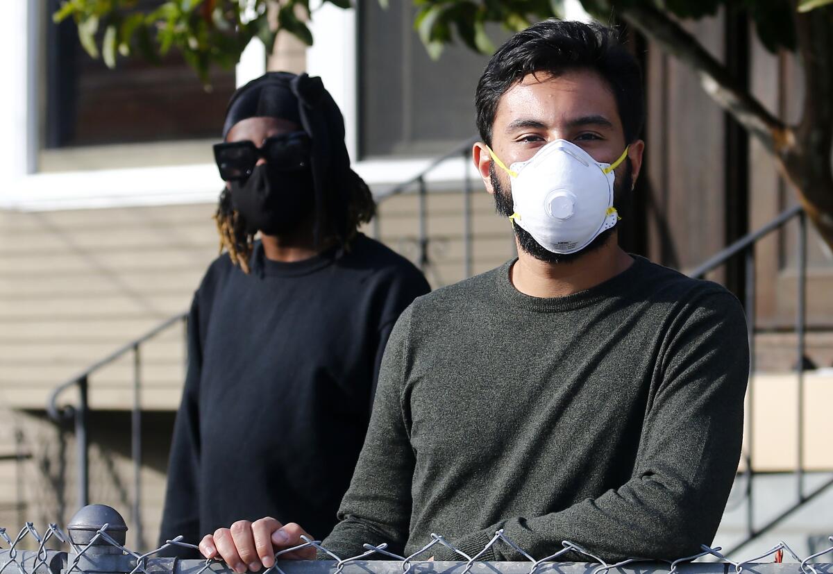 Oko Carter, 30, left, and Andres Vidaurre share a home in Los Angeles with eight other people.