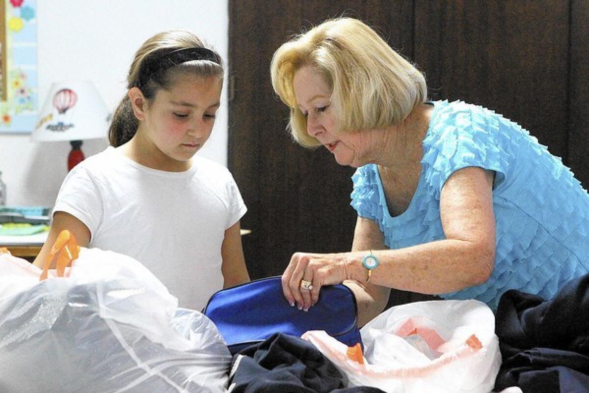 Personal dresser Pat Spencer, right, goes through the bathroom kit with third grader Angela Krikorian, 8, at Assistance League of Glendale on Monday, January 13, 2014. Since October, the Assistance League's Operation School Bell program prepared bags of clothing for school children, recommended by the school, that includes at least three changes of clothes, hooded sweatshirt, $15 coupon for shoes, socks, underwear, bathroom kit, and a book of their choice.