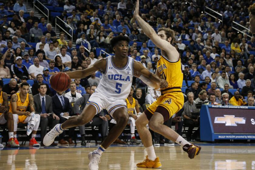 UCLA guard Chris Smith (5) drives against Arizona State forward Mickey Mitchell (00) during an NCAA college basketball game Thursday, Feb. 27, 2020, in Los Angeles. (AP Photo/Ringo H.W. Chiu)