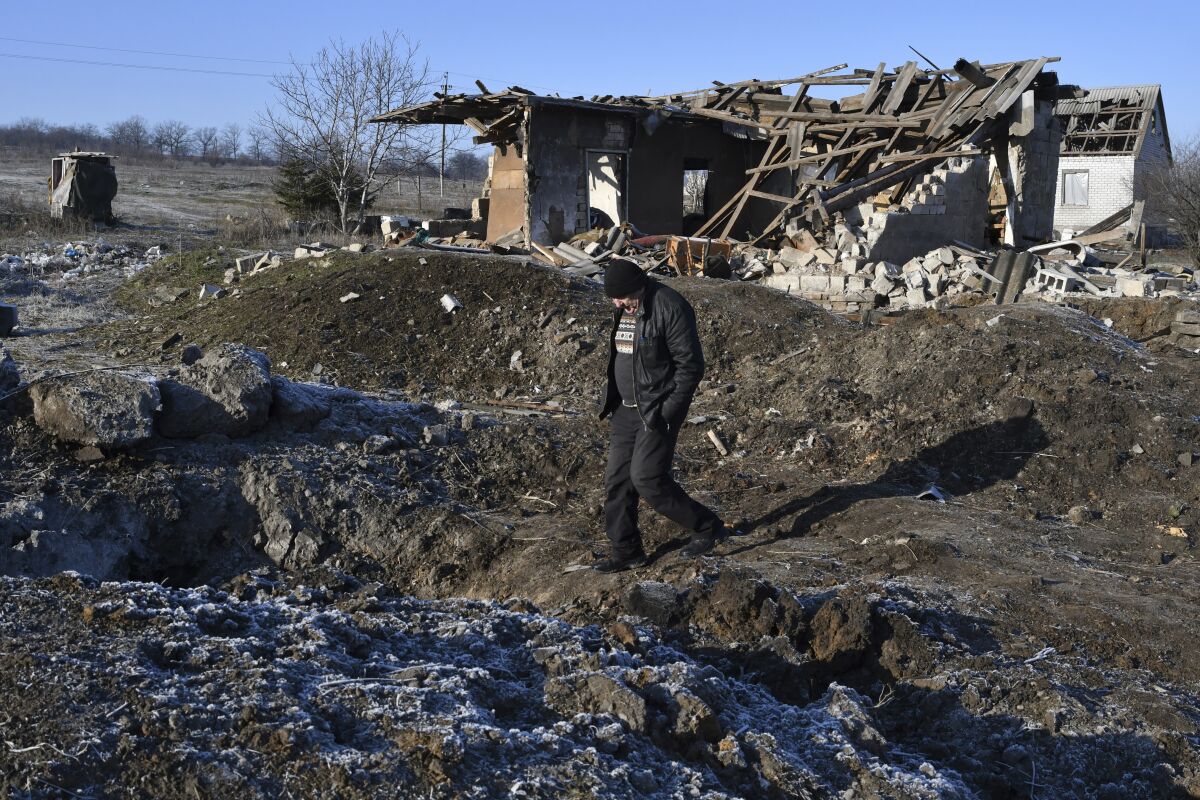 Man outside a house destroyed by a Russian rocket