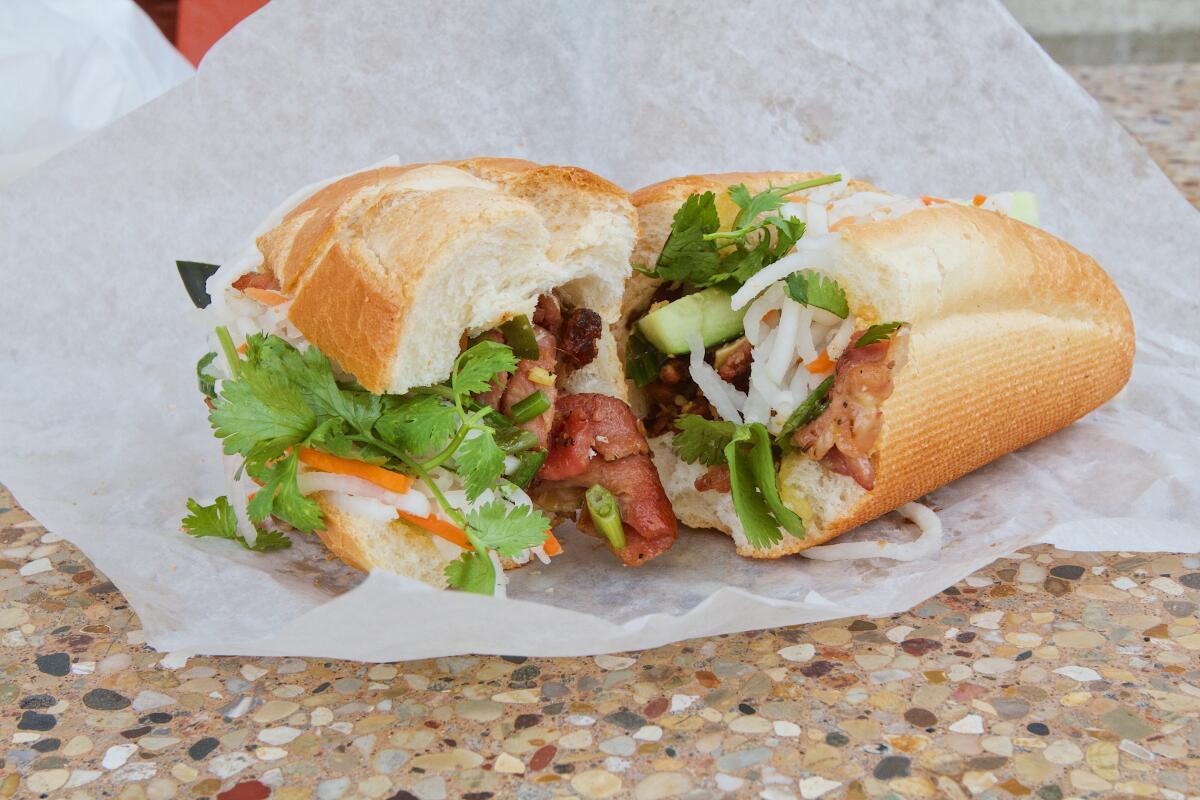 A photo of a grilled-pork Banh Mi My-Tho banh mi sandwich split in half.