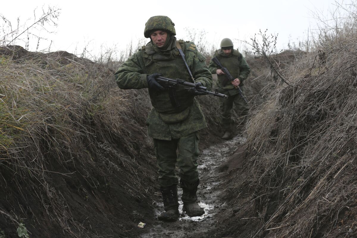 Serviceman walk in a trench at the line of separation near Sentianivka, Luhansk region, controlled by Russia-backed separatists, eastern Ukraine, Thursday, Dec. 9, 2021. Russia's military warned the Ukrainian government Thursday against trying to settle a separatist conflict in eastern Ukraine with force, a statement that adds to the tensions sparked by a Russian troop buildup near the Ukrainian border. (AP Photo/Alexei Alexandrov)
