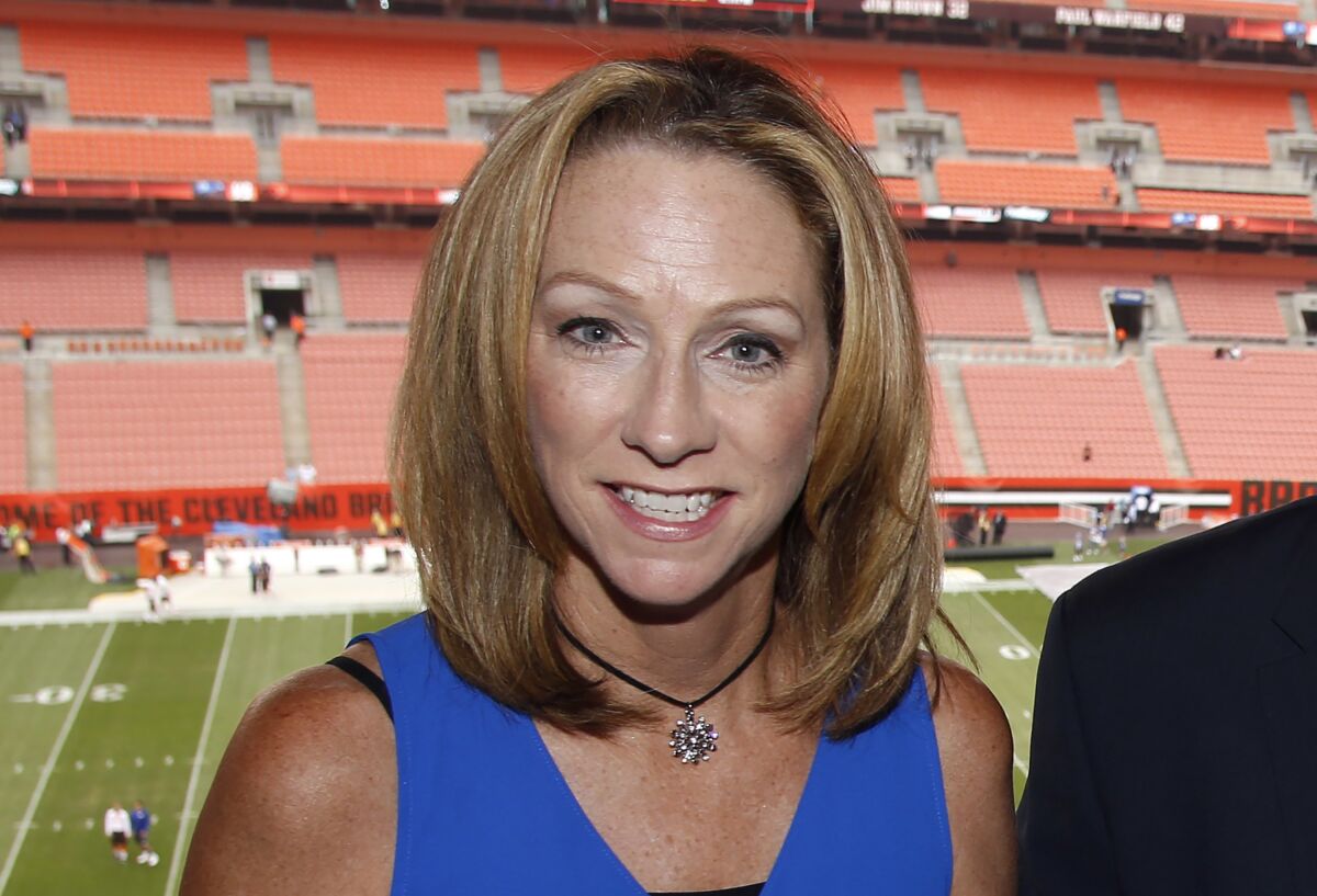 FILE - ESPN broadcaster Beth Mowins poses in the booth before an NFL football game between the New York Giants and the Cleveland Browns, Monday, Aug. 21, 2017, in Cleveland. Mowins made ESPN history in 2017 when she was the first woman to call a “Monday Night Football” game. She will again be part of a network first on Wednesday, Feb.9, 2022, when ESPN produces an NBA game announced and directed by all women.(AP Photo/Ron Schwane, File)