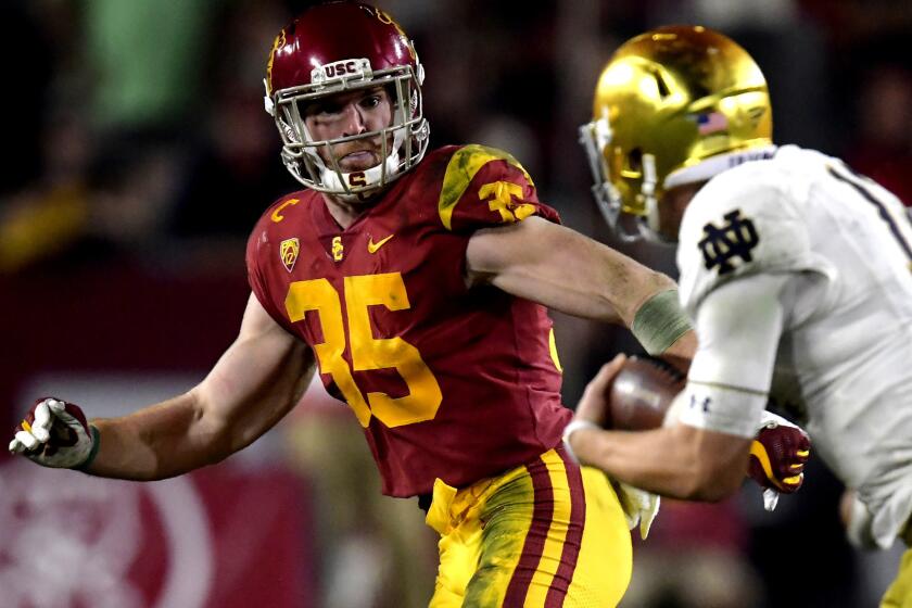 Southern California linebacker Cameron Smith, left, chases down Notre Dame quarterback Ian Book during the second half of an NCAA college football game Saturday, Nov. 24, 2018, in Los Angeles. Notre Dame won 24-17. (AP Photo/Mark J. Terrill)