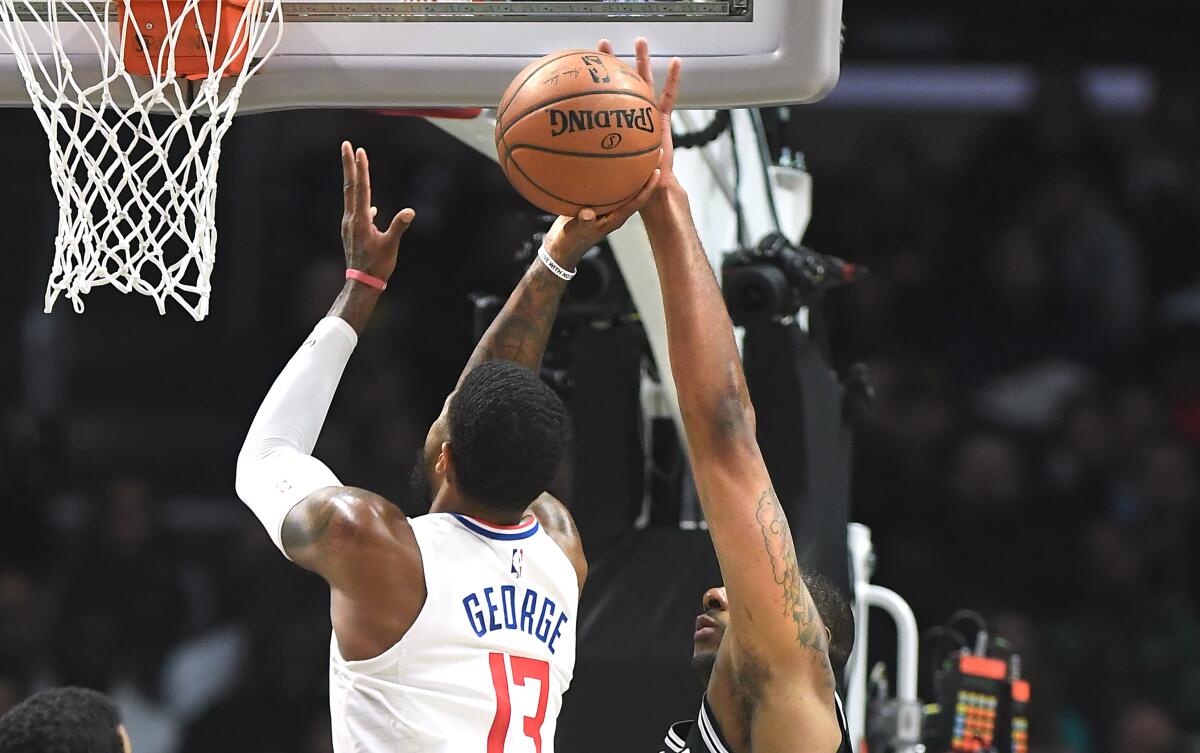 Clippers forward Paul George tries to put up a shot over Spurs forward LaMarcus Aldridge during the second quarter of the Clippers' 108-105 win Monday at Staples Center.