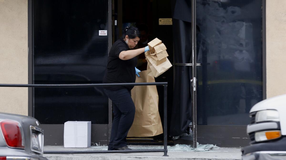 Los Angeles County Sheriff Department Crime Lab investigators gather bags of evidence at a pot dispensary in Walnut Park where one of the store owners shot and critically wounded two men attempting to rob the store.