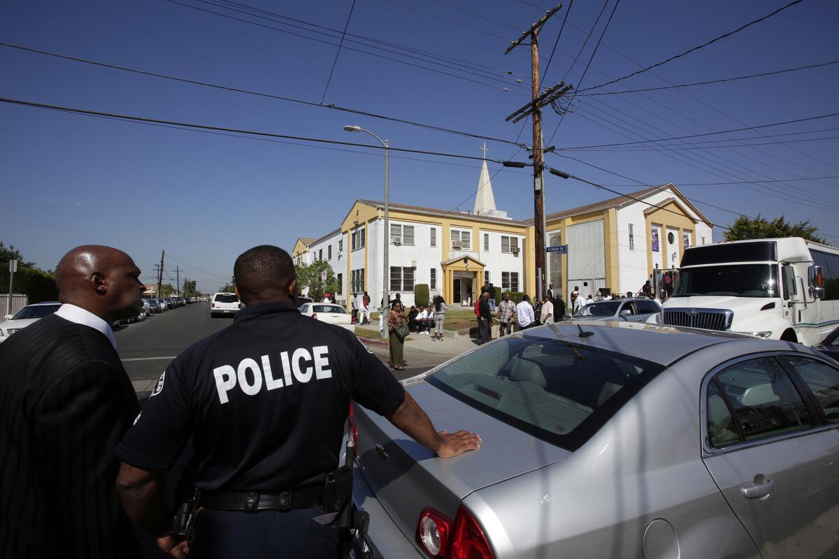 Los Angeles police officers watch over a funeral in Compton in October.