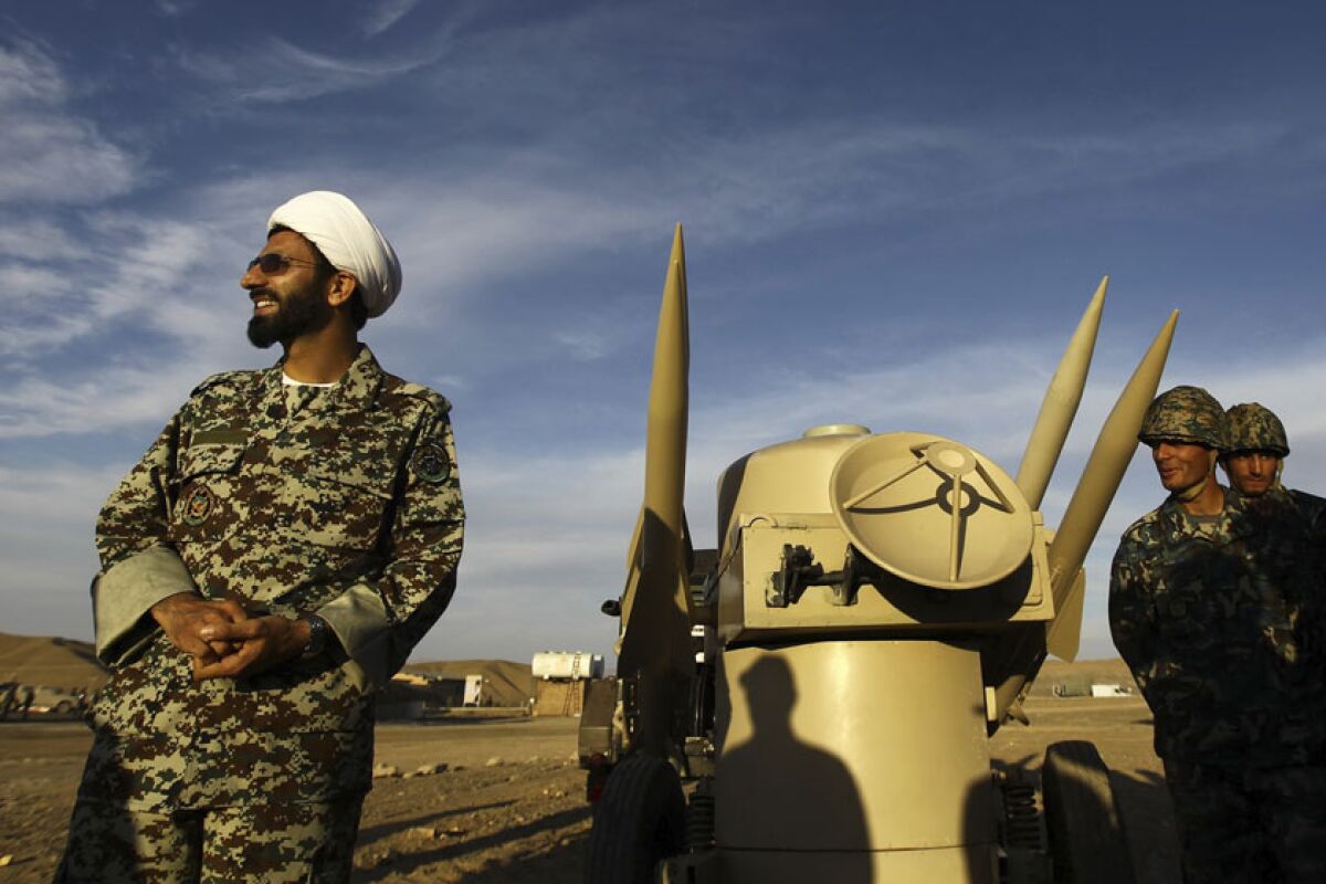 An Iranian clergyman near missiles at an undisclosed location.