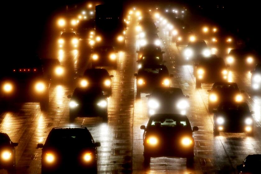 LONG BEACH, CALIF. - JAN. 3, 2023. Motor traffic stacks up on the rain-slicked 405 Freeway in Long Beach during rush hour on Tuesday, Jan. 3, 2023. (Luis Sinco / Los Angeles Times)