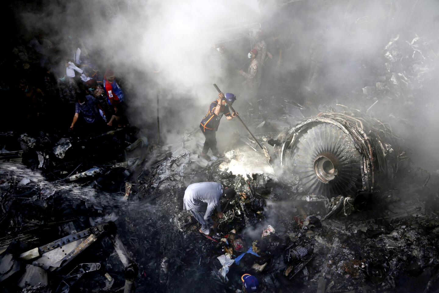 Volunteers search for survivors amid the wreckage of a Pakistani airliner that crashed Friday in a neighborhood in Karachi.
