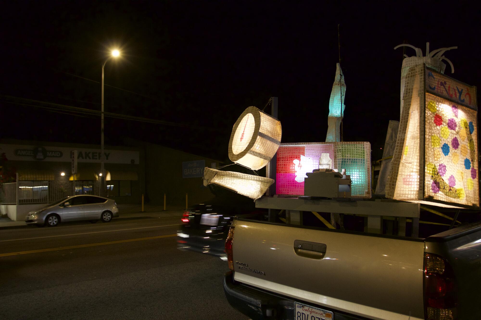 a nighttime photo of a truck filled with paper lanterns