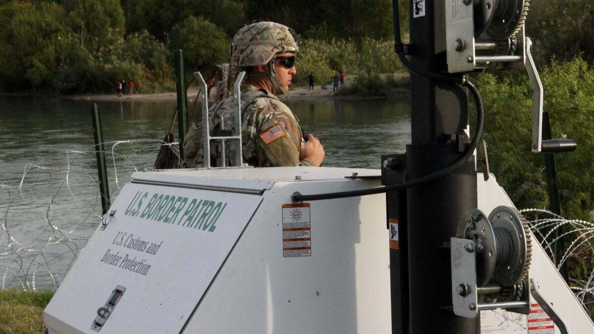 A soldier from the Kentucky-based 19th Engineer Battalion looks across the Rio Grande River from Laredo, Texas, into Nuevo Laredo, Mexico, where a group of people hang out on the river bank on November 17, 2018. - The soldiers are some of the thousands of US troops deployed to the US-Mexico border as part of a mission ordered by President Donald Trump to toughen the frontier and provide engineering and logistical support to Customs and Border Protection agents. (Photo by Thomas WATKINS / AFP)THOMAS WATKINS/AFP/Getty Images ** OUTS - ELSENT, FPG, CM - OUTS * NM, PH, VA if sourced by CT, LA or MoD **