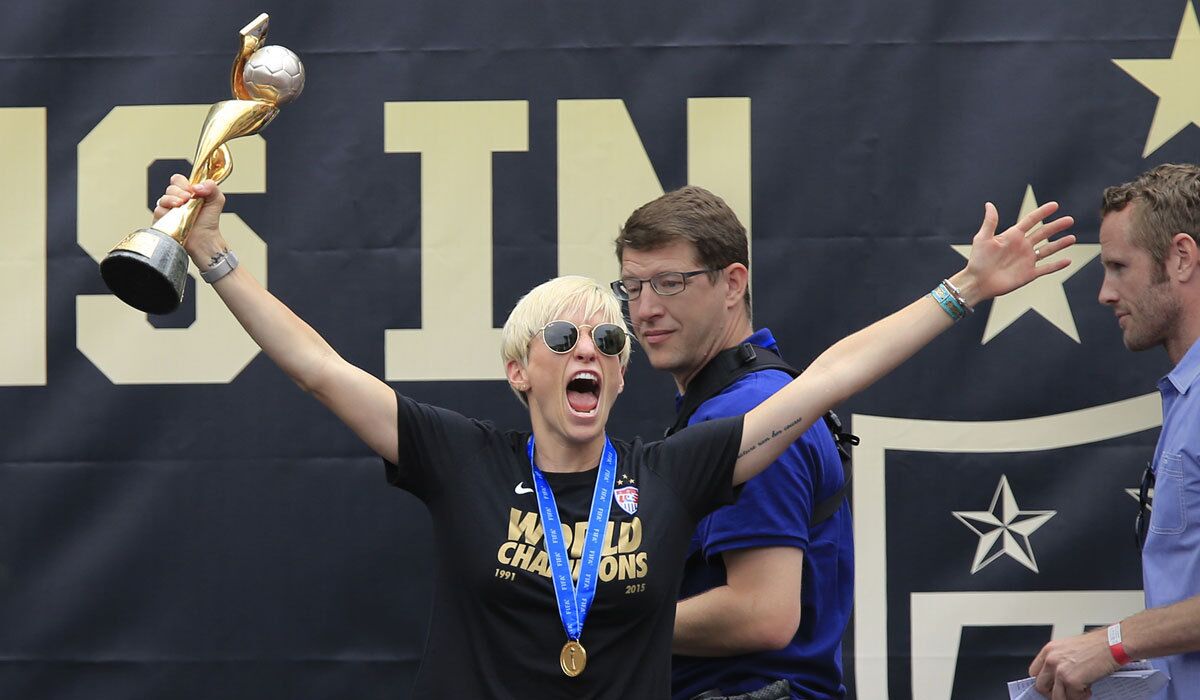 Megan Rapinoe hoists the World Cup trophy during a public celebration at L.A. Live's Microsoft Square on July 7, 2015.