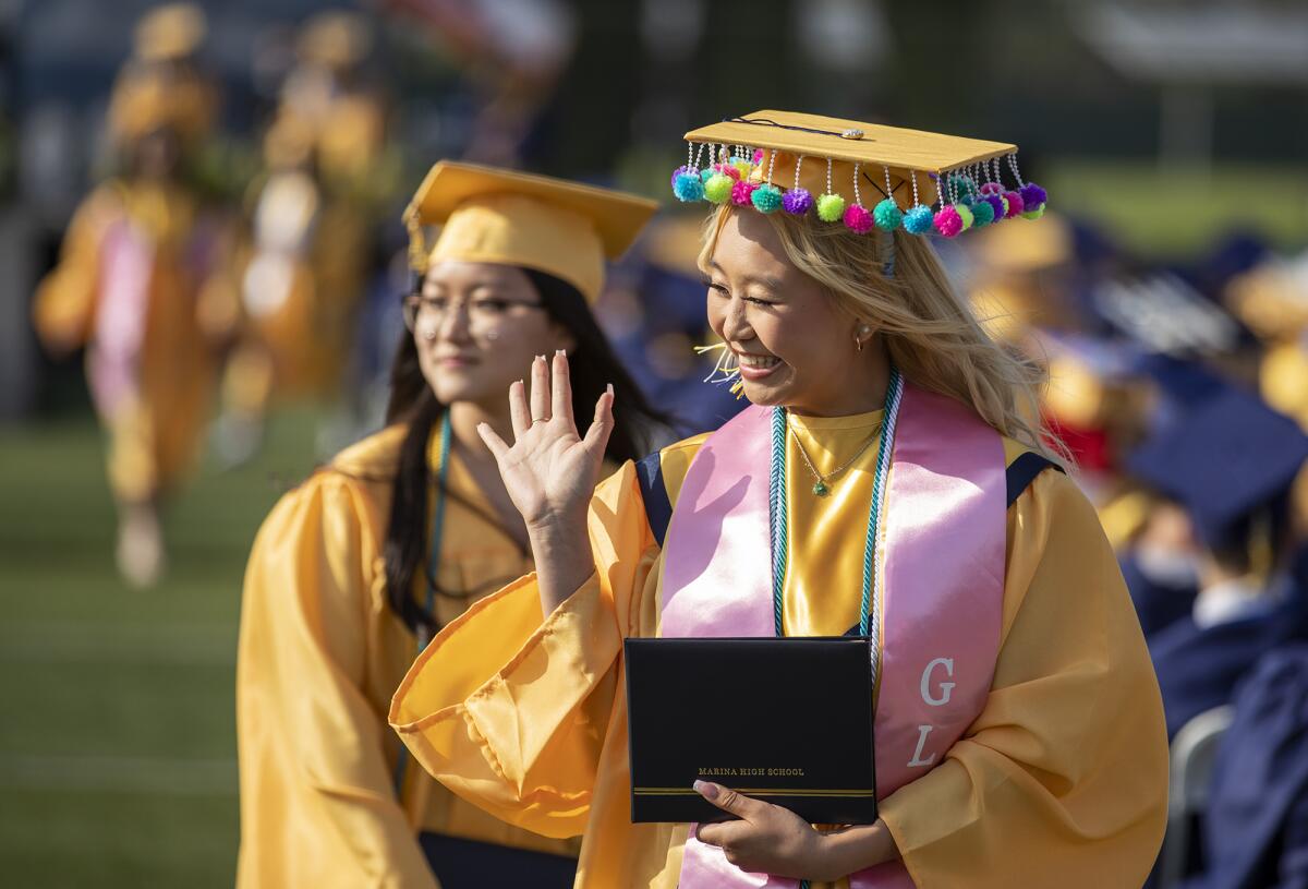 Grace Lee waves to a fellow graduate during the Marina High commencement ceremony at Westminster High School on Thursday.