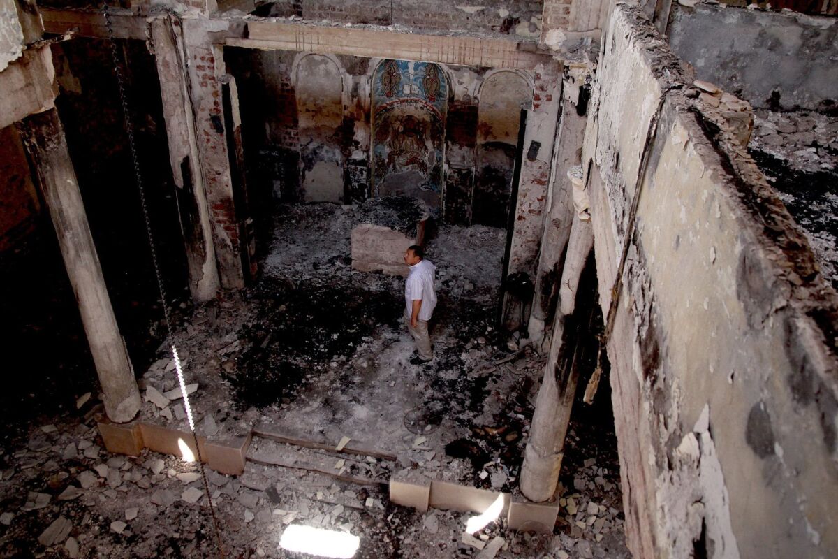 Man stands amid rubble at the St. John Church that was burned by mobs in Abnoub, south of Cairo, in August.