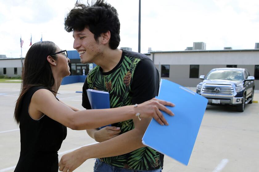 U.S. citizen Francisco Galicia, 18, gets a hug from his attorney, Claudia Galan, after his release from the South Texas Detention Facility in Pearsall, Texas, Tuesday, July 23, 2019. Galicia was released from immigration custody Tuesday after wrongfully being detained for more than three weeks. Galicia lives in the border city of Edinburg, Texas, and was traveling north with a group of friends when they were stopped at a Border Patrol inland checkpoint. According to Galan and the Dallas Morning News, agents apprehended Galicia on suspicion that he was in the U.S. illegally even though he had a Texas state ID. (Kin Man Hui/The San Antonio Express-News via AP)